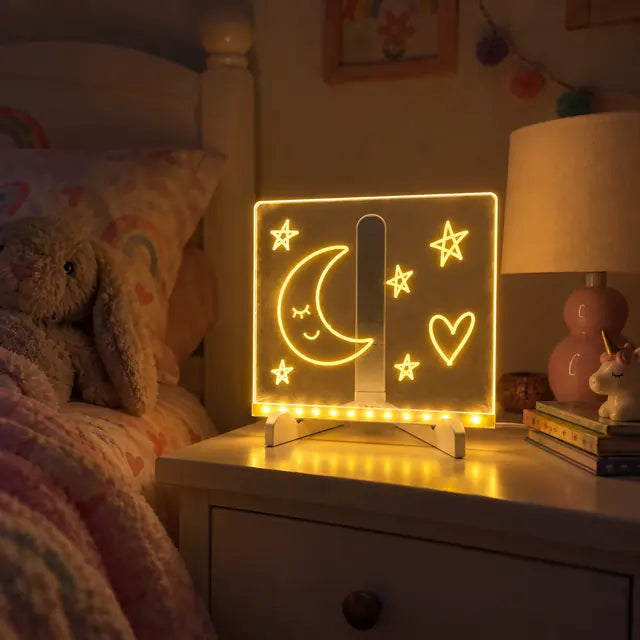 Acrylic LED board glowing with moon and stars on a bedside table
