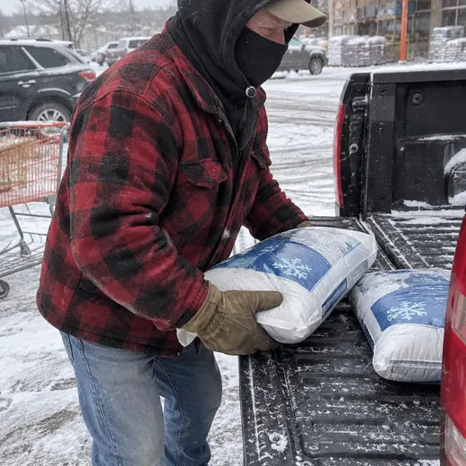 Customer loading supplies in snowy parking lot wearing black hood