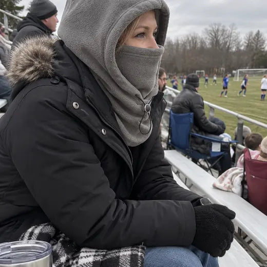 Customer watching outdoor game wearing gray fleece hood