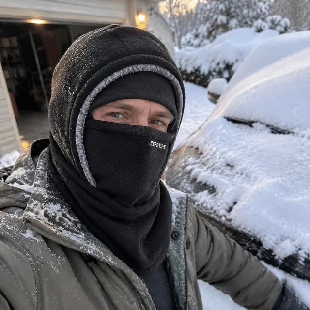 Black winter hood selfie beside a snow-covered car